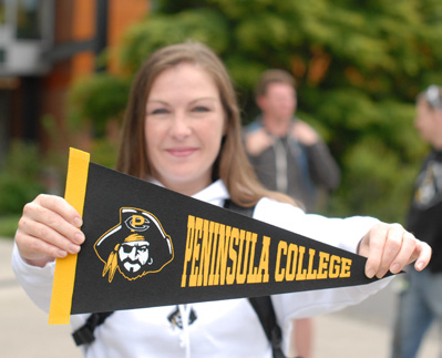 Woman Holding Peninsula College Pennant